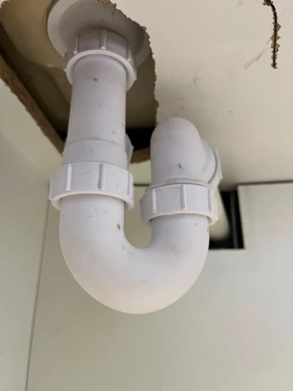 Repaired white pipework beneath a sink